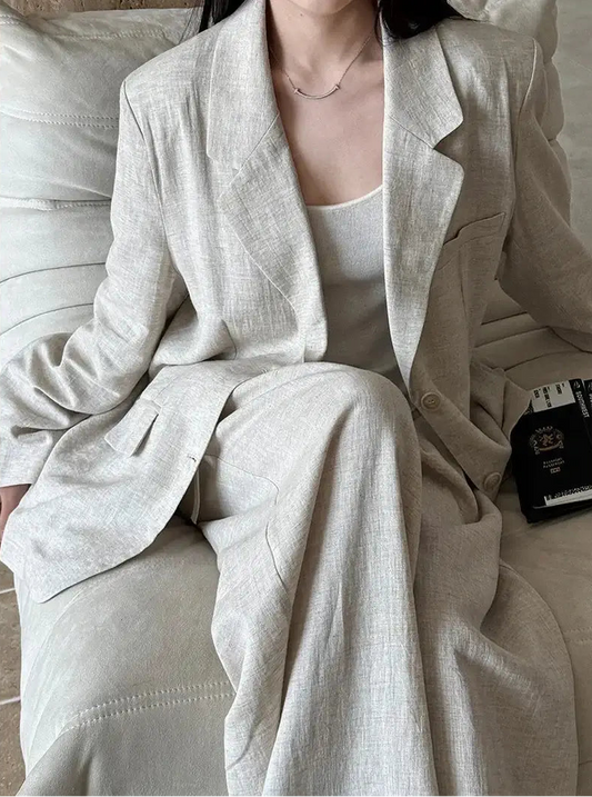 Person wearing a light gray suit sitting on a couch.