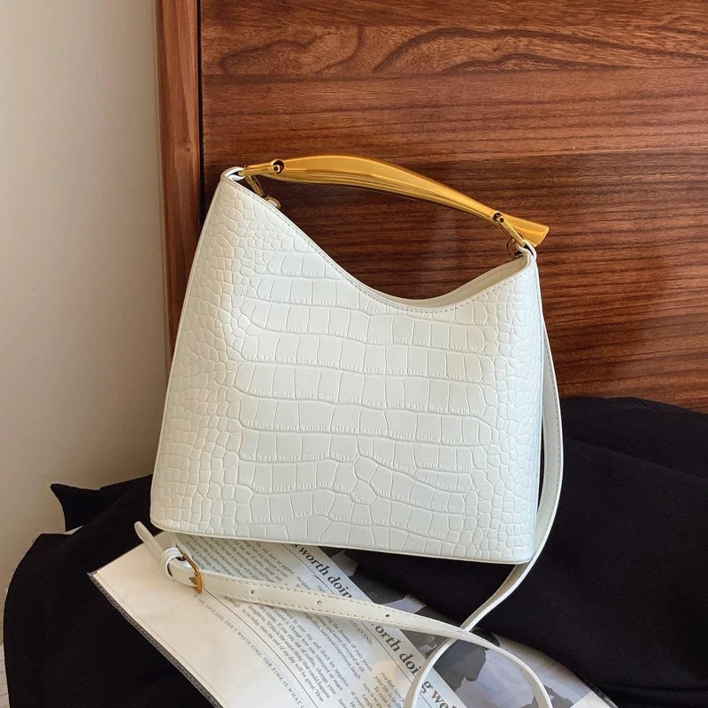 White textured handbag with yellow handle on a surface