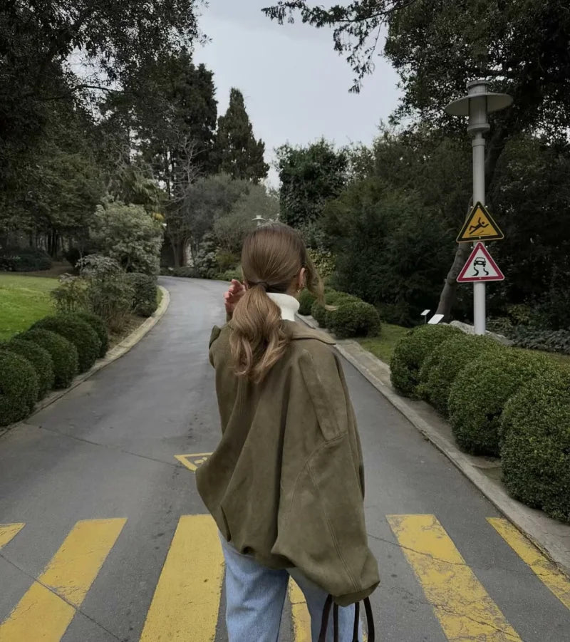 Person walking on a path with trees and road signs in the background