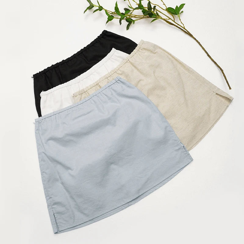 Three skirts in black, white, and beige on a light background with a branch.