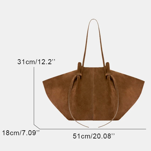 A brown suede tote bag shown with dimension lines and text indicating measurements: 31 cm height, 18 cm width, and 51 cm base, on a light gray background.