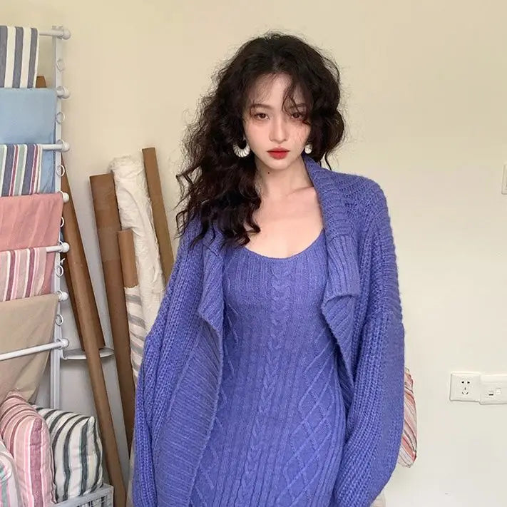 Woman wearing a blue knitted cardigan over a matching dress in a room with fabric rolls.