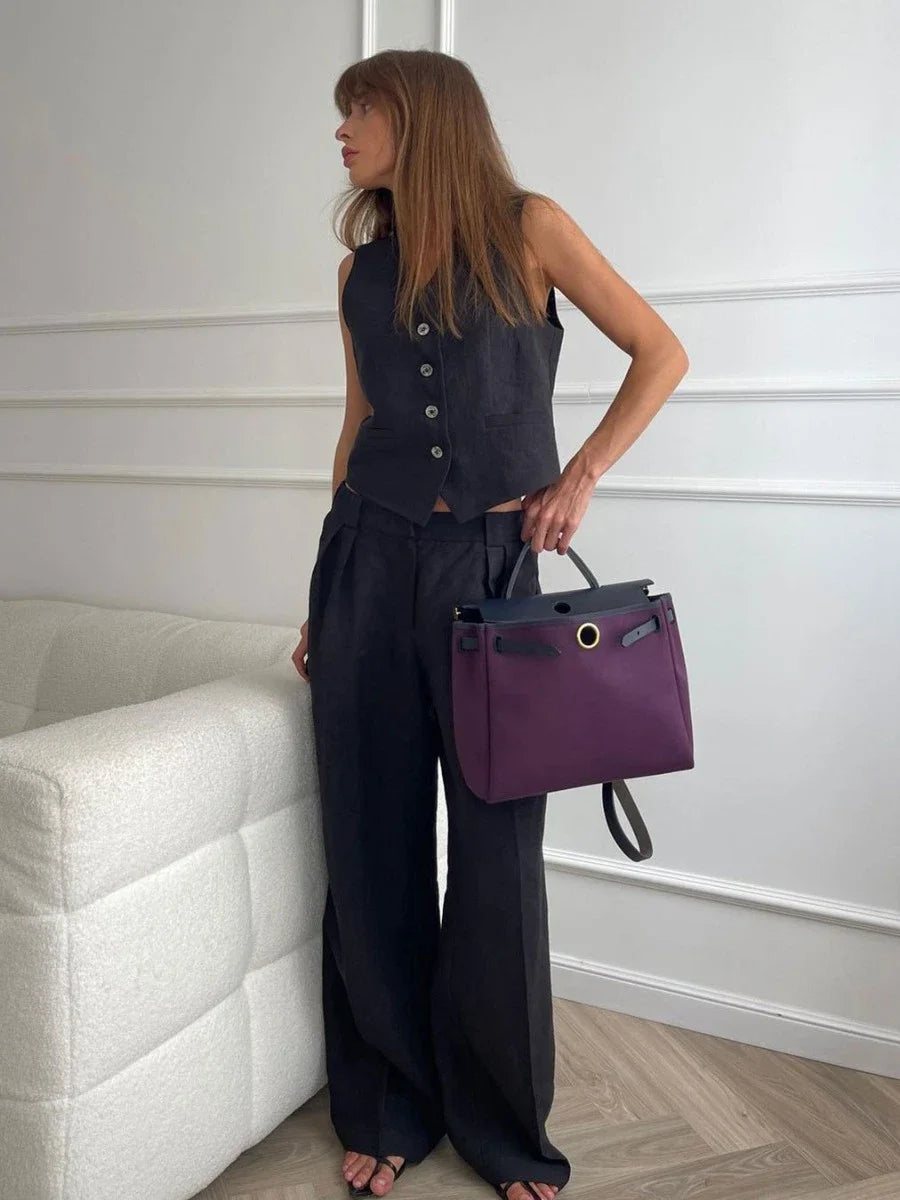 Woman holding a purple handbag in an indoor setting