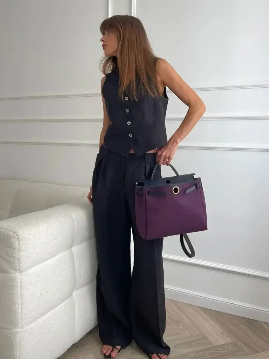 Woman holding a purple handbag in an indoor setting