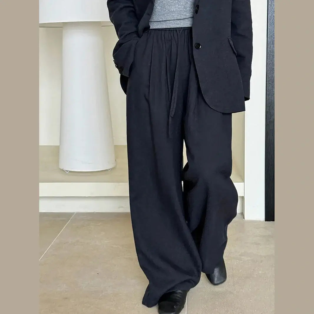 Person wearing a blue suit with wide-leg pants indoors.