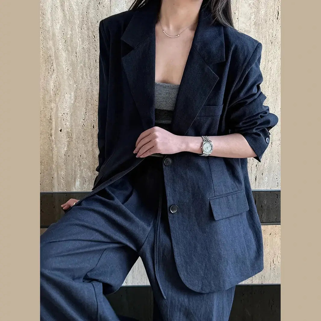Person wearing a navy suit with a neutral background