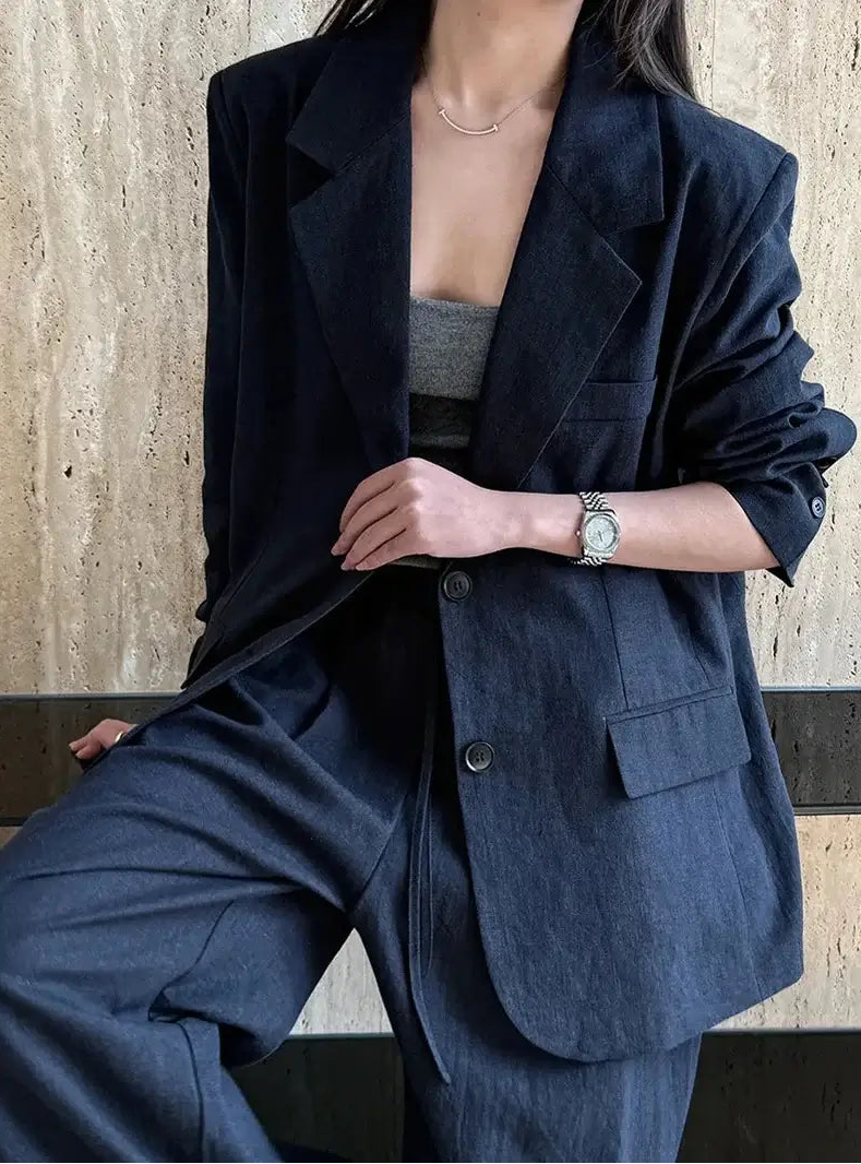 Person wearing a navy suit with a neutral background