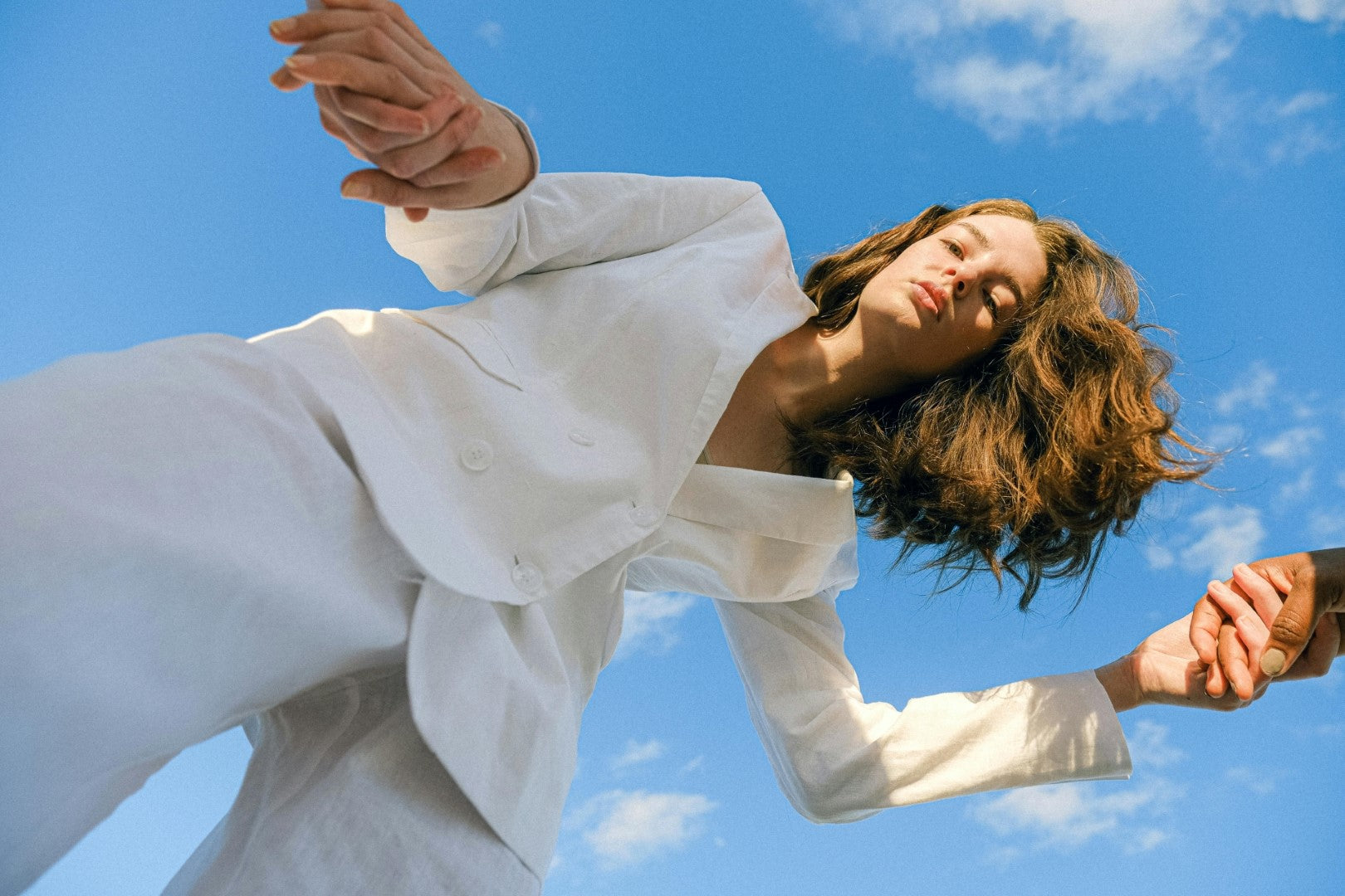 Person in a white shirt against a blue sky