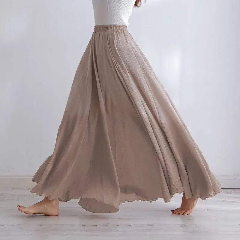 Person wearing a long beige skirt against a white background