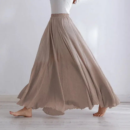 Person wearing a long beige skirt against a white background