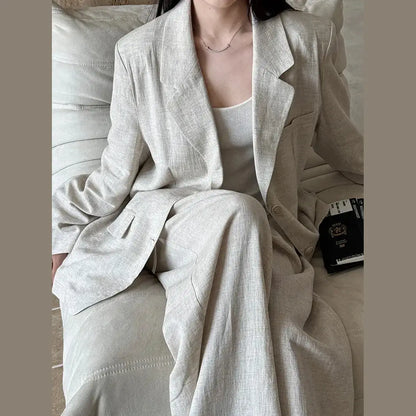 Person wearing a light gray suit sitting on a couch.