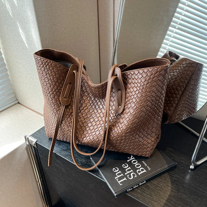 Brown woven handbag on a book with a blurred background