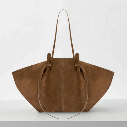 Brown suede handbag on a white background