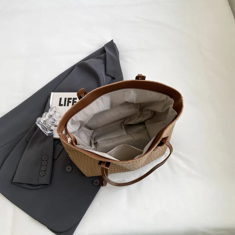 Brown woven bag with gray interior on a white surface next to a gray jacket and 'LIFE' magazine.