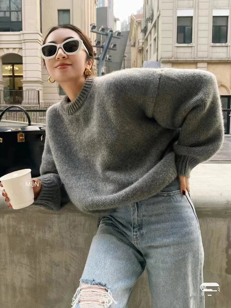 Front view of woman wearing the loose-fit pure cashmere crewneck sweater in undyed cream.