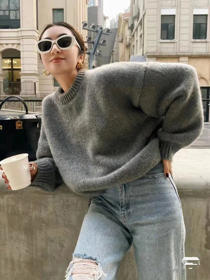 Front view of woman wearing the loose-fit pure cashmere crewneck sweater in undyed cream.