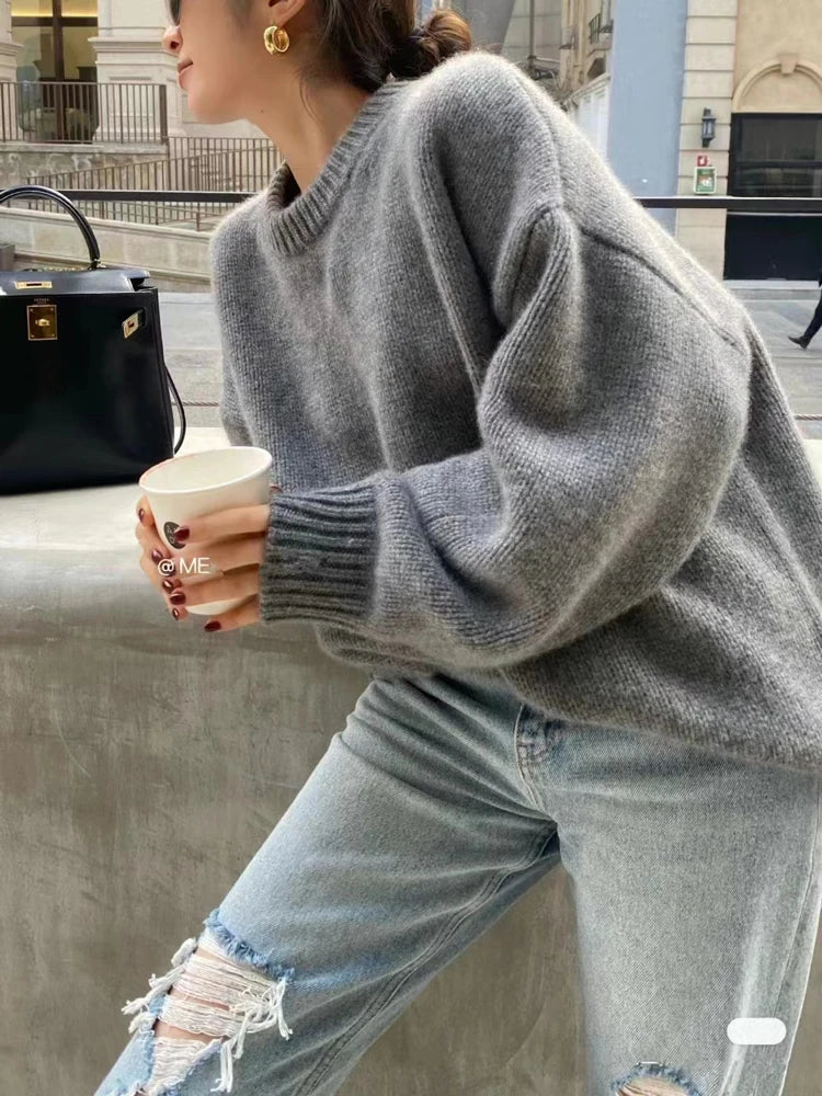 Front view of woman wearing the loose-fit pure cashmere crewneck sweater in undyed cream.
