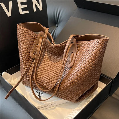 Brown woven handbag in a box with a blurred background