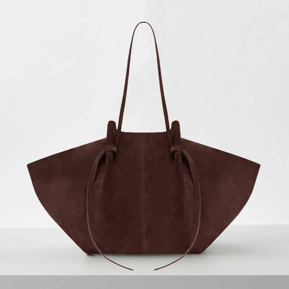 Brown suede handbag on a white background