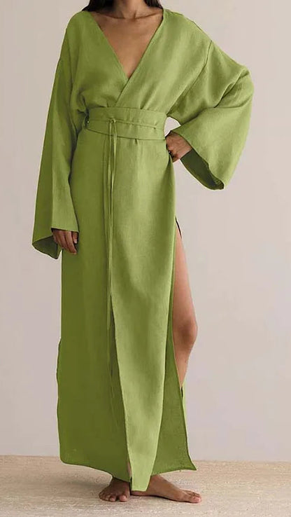 Green long dress with wide sleeves on a neutral background