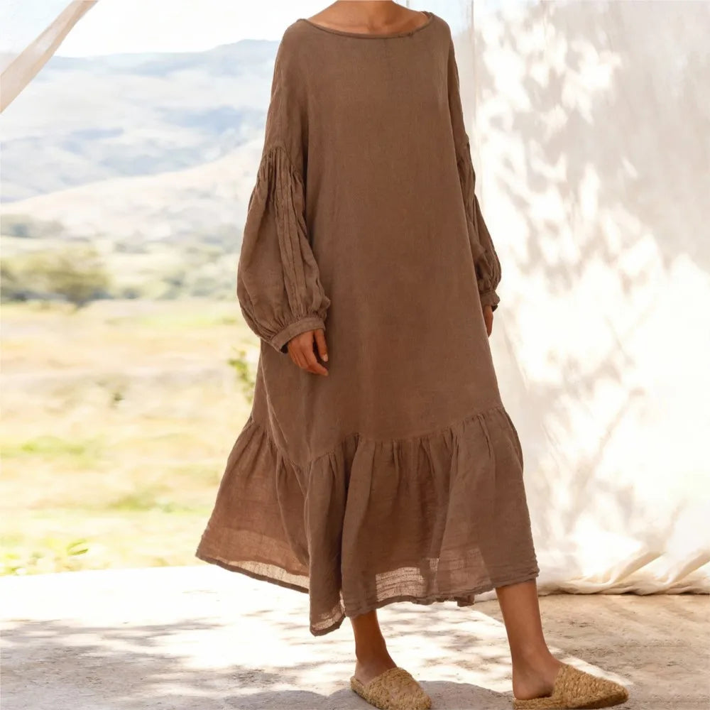 Front view of woman wearing loose-fit cotton linen midi dress in neutral tone with lantern sleeves