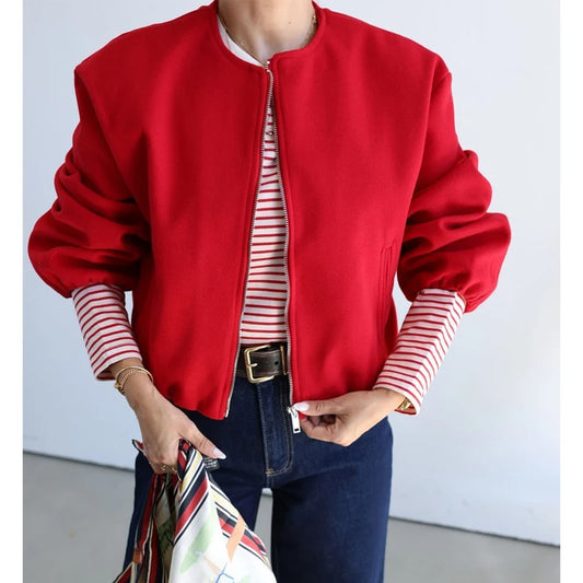 Person wearing a red jacket with striped sleeves against a light background