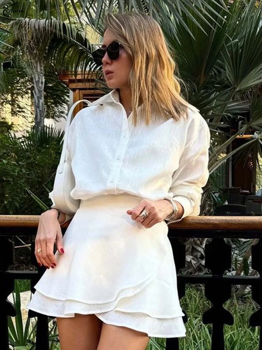 Woman wearing a white outfit with sunglasses in a tropical setting