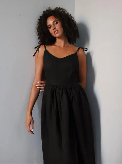 Woman wearing a black dress against a plain background