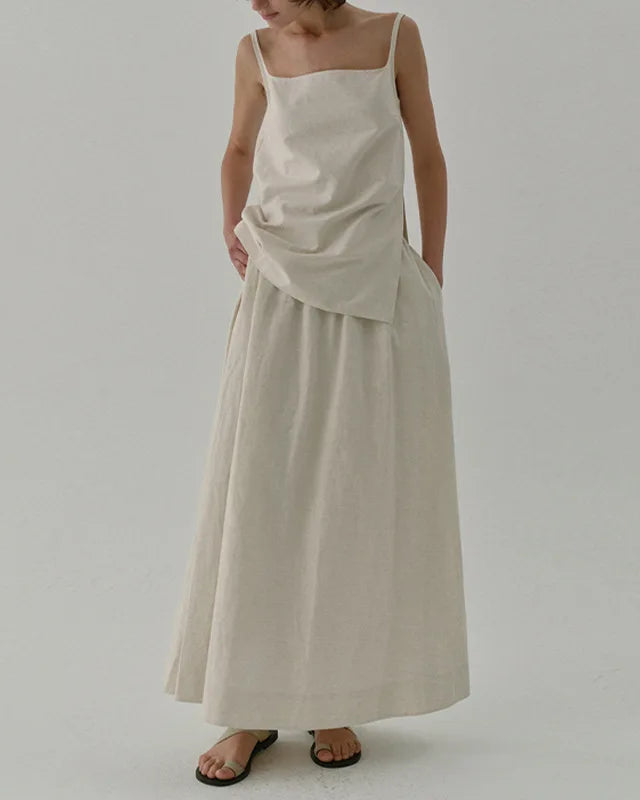 Person wearing a beige dress with a plain background